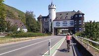 Radfahrer auf dem Moselradweg fährt auf eine Burg zu